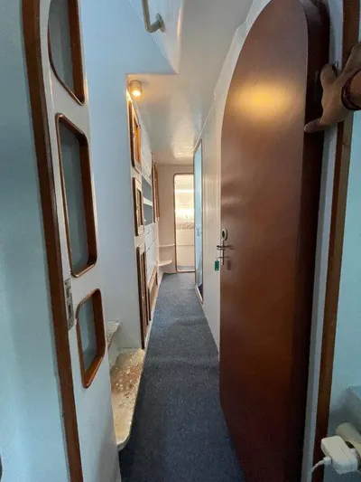 Ps 70 Yacht Photos Pics Narrow corridor inside 1990 Shuttleworth BLUE PEGASUS 70 yacht, featuring wooden door and built-in storage.