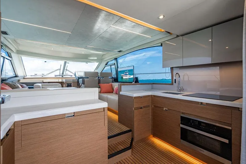 Grace Yacht Photos Pics Luxurious interior of 2022 Beneteau Monte Carlo 52 yacht with modern kitchen and seating area.