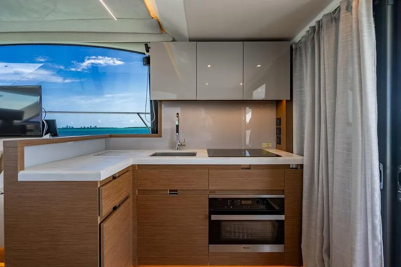 Grace Yacht Photos Pics Modern kitchen interior on 2022 Beneteau Monte Carlo 52 yacht, featuring sleek cabinetry and ocean view.