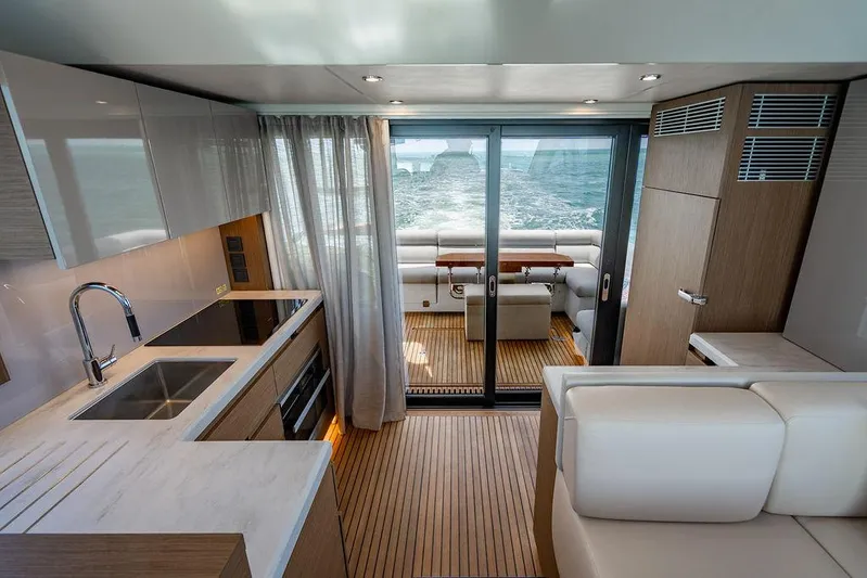 Grace Yacht Photos Pics Luxurious interior of 2022 Beneteau Monte Carlo 52 yacht with modern kitchen and ocean view.
