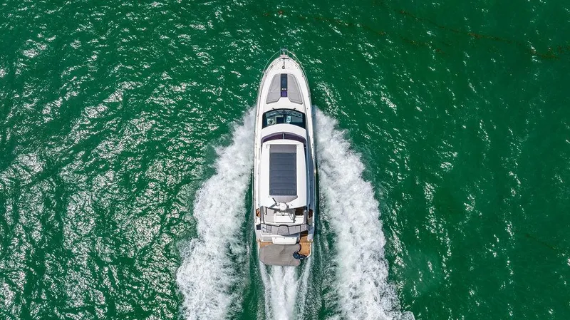 Grace Yacht Photos Pics Aerial view of 2022 Beneteau Monte Carlo 52 yacht cruising on turquoise water.