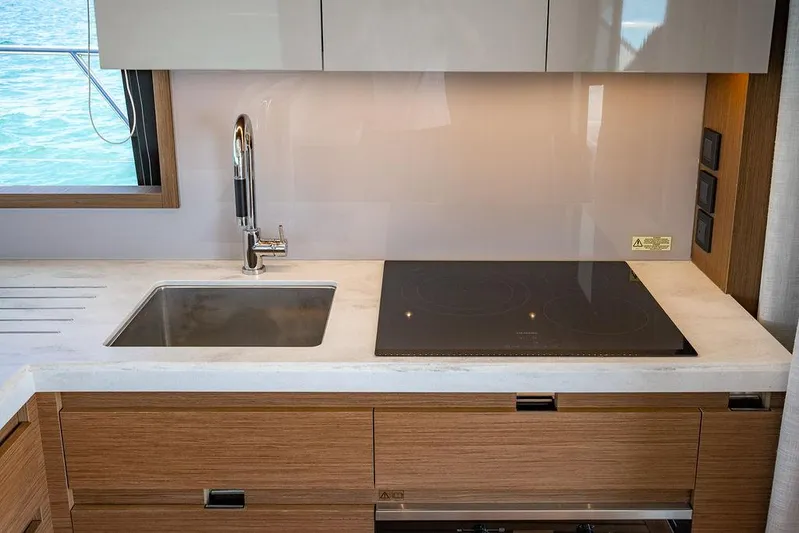 Grace Yacht Photos Pics Modern kitchen in 2022 Beneteau Monte Carlo 52 yacht with sink and induction cooktop.
