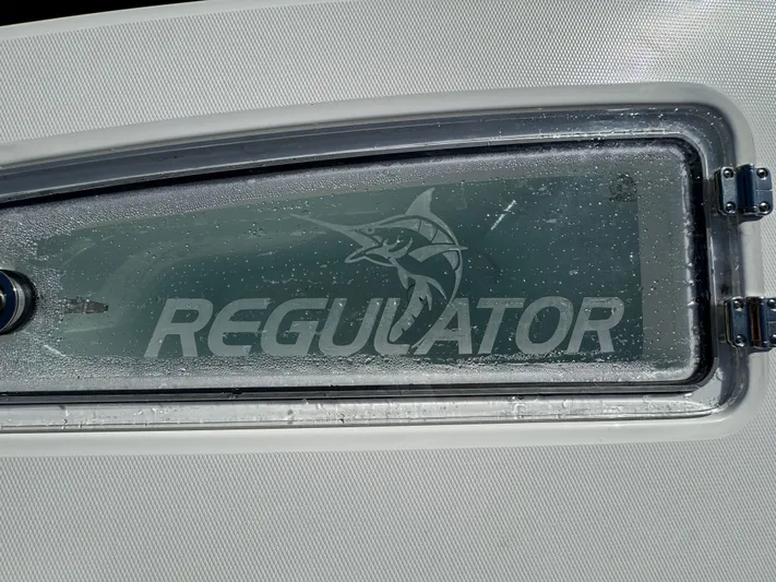  Yacht Photos Pics Regulator 31 boat window with logo, 2025 model, featuring water droplets.