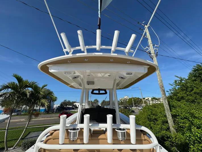  Yacht Photos Pics 2025 Regulator 31 boat with rod holders and canopy, set against a clear blue sky.