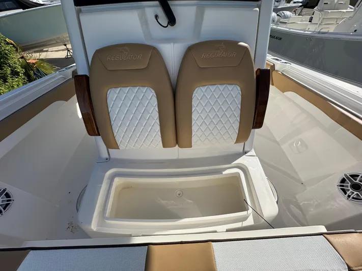  Yacht Photos Pics 2025 Regulator 31 boat interior with tan and white cushioned seats and storage compartment.