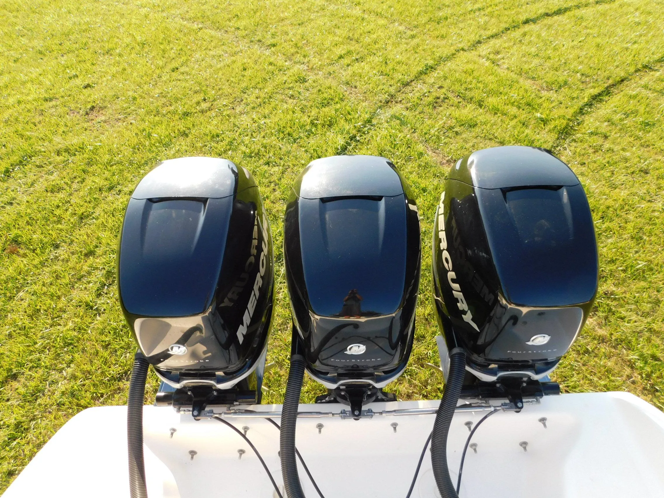 Three Mercury outboard motors on a Solid Craft LIMITED 40 boat, 2005 model, on grass.