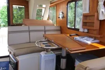  Yacht Photos Pics 2021 Ranger Tugs R-31 CB interior with wooden table, seating, and windows.