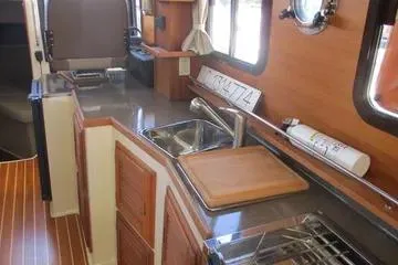  Yacht Photos Pics 2021 Ranger Tugs R-31 CB interior kitchen with wooden cabinetry and modern appliances.