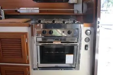  Yacht Photos Pics 2021 Ranger Tugs R-31 CB kitchen with stainless steel oven and wooden cabinetry.