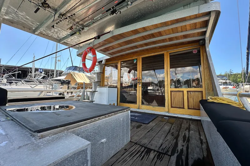 Lone Wolf Yacht Photos Pics Custom 2002 Carlson Marine Trawler with wooden doors, docked at marina, featuring outdoor seating and equipment.