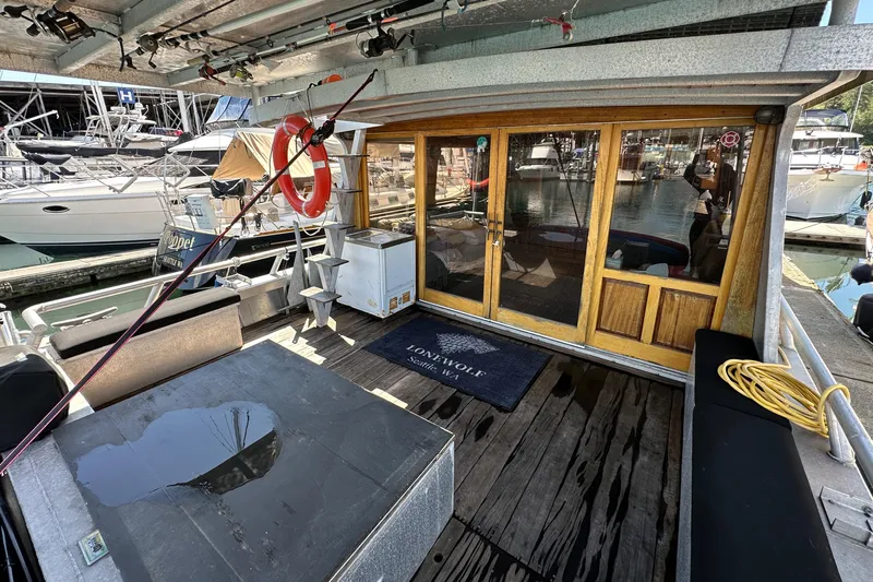 Lone Wolf Yacht Photos Pics Custom 2002 Carlson Marine Trawler docked, featuring wooden doors, seating, and nautical equipment.