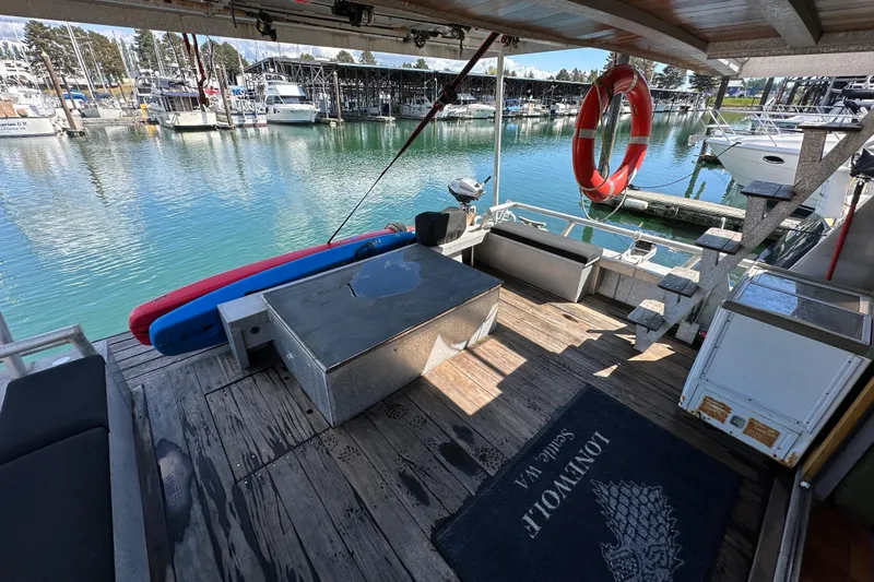 Lone Wolf Yacht Photos Pics Deck of 2002 Carlson Marine Trawler with seating, life ring, and marina view.