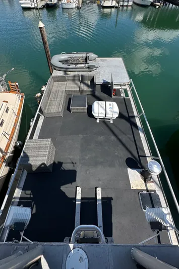 Lone Wolf Yacht Photos Pics Custom 2002 Carlson Marine Trawler docked, featuring spacious deck and moored boats in background.