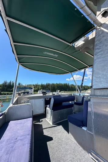 Lone Wolf Yacht Photos Pics Custom 2002 Carlson Marine Trawler interior with canopy, seating, and scenic marina view.