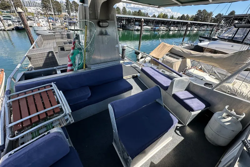 Lone Wolf Yacht Photos Pics Custom 2002 Carlson Marine Trawler with blue seating, docked at marina.