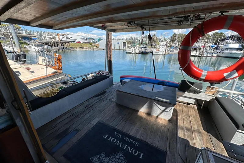 Lone Wolf Yacht Photos Pics Custom 2002 Carlson Marine Trawler docked, featuring spacious deck with seating and life preserver.