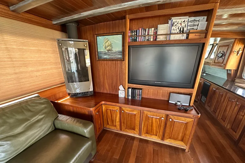 Lone Wolf Yacht Photos Pics Luxurious 2002 Carlson Marine Trawler interior with wood paneling, TV, and cozy seating area.