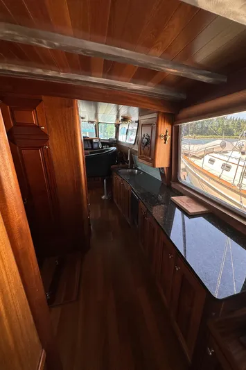 Lone Wolf Yacht Photos Pics Luxurious wooden interior of a 2002 Carlson Marine Trawler with sleek countertops and scenic windows.