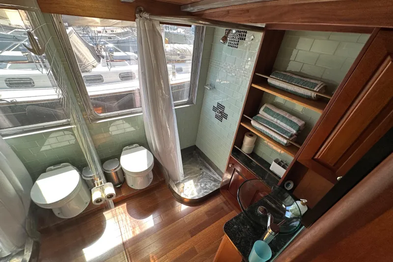 Lone Wolf Yacht Photos Pics Luxurious bathroom in 2002 Carlson Marine Trawler with shower, dual toilets, and wooden accents.