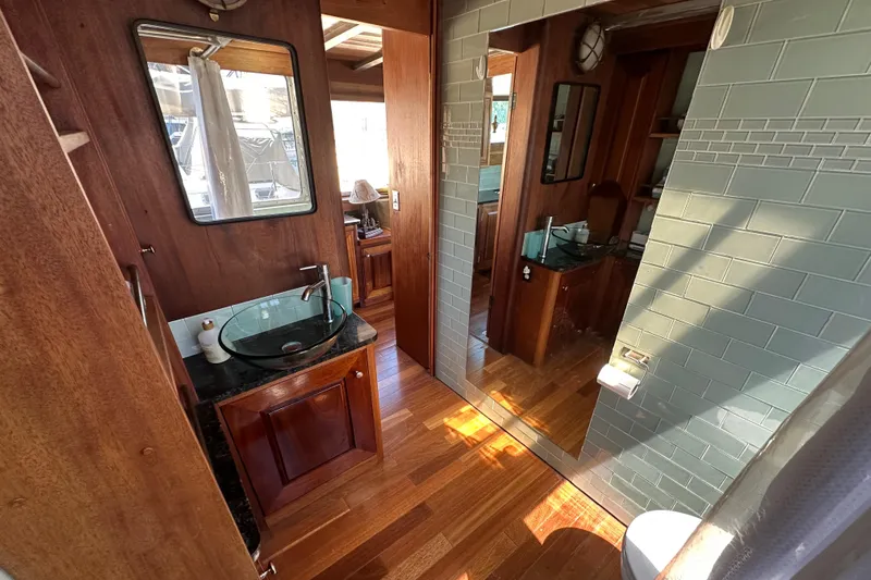 Lone Wolf Yacht Photos Pics Luxurious bathroom interior on 2002 Carlson Marine Trawler with wood accents and glass sink.