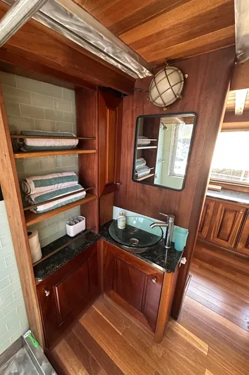 Lone Wolf Yacht Photos Pics Cozy wooden bathroom in 2002 Carlson Marine Trawler with sink, mirror, and shelves.