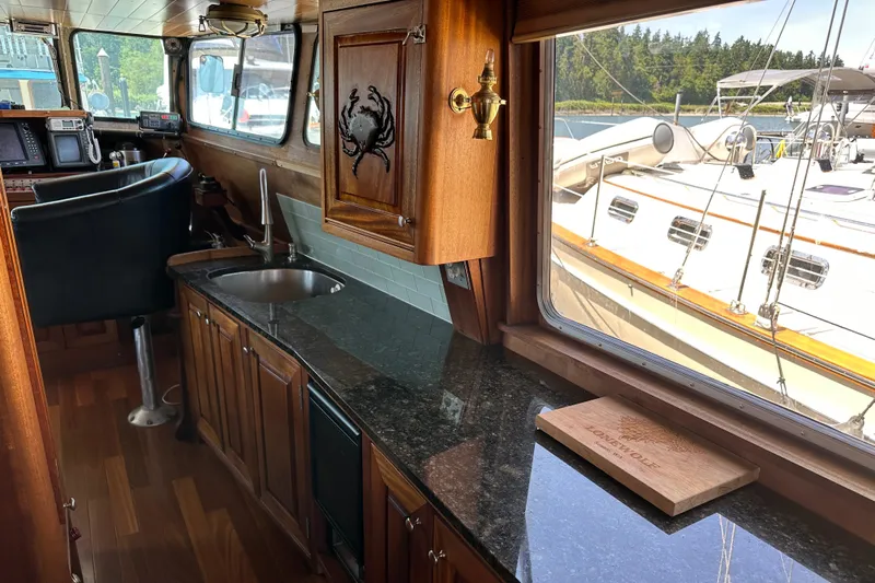 Lone Wolf Yacht Photos Pics Interior of 2002 Carlson Marine Trawler with wooden cabinetry and granite countertop.