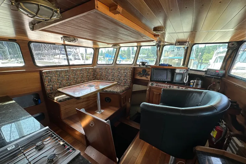 Lone Wolf Yacht Photos Pics Interior of 2002 Carlson Marine Trawler with seating, navigation equipment, and wood paneling.
