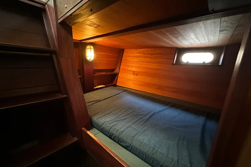 Lone Wolf Yacht Photos Pics Cozy wooden cabin interior of 2002 Carlson Marine Trawler with bed and porthole window.