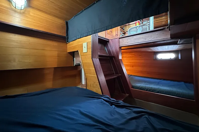 Lone Wolf Yacht Photos Pics Cozy wooden cabin interior of 2002 Carlson Marine Trawler with bunk beds and ladder.