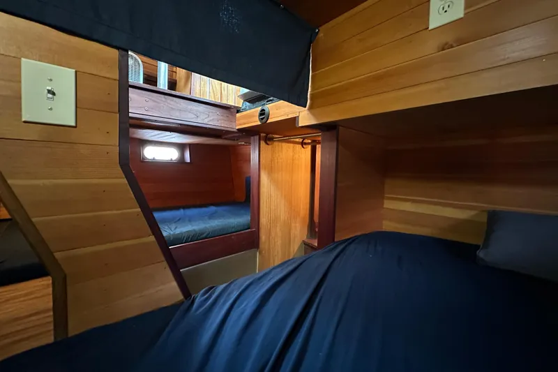 Lone Wolf Yacht Photos Pics Cozy wooden cabin interior of 2002 Carlson Marine Trawler with bunk beds and soft lighting.