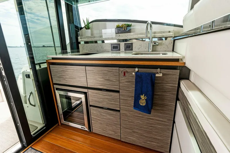 Victory Yacht Photos Pics Modern kitchenette on 2019 Tiara Yachts 49 COUPE with sleek cabinetry and ocean view.
