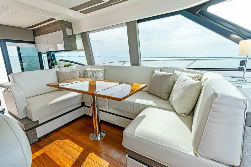 Victory Yacht Photos Pics Luxurious interior of 2019 Tiara Yachts 49 COUPE with white seating and wooden table.