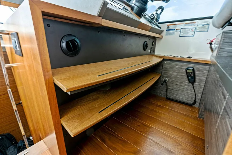 Victory Yacht Photos Pics Interior helm station of 2019 Tiara Yachts 49 COUPE with wooden shelves and control panel.