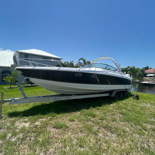  Yacht Photos Pics 2005 Formula 330 SS boat on trailer, parked on grass under clear blue sky.
