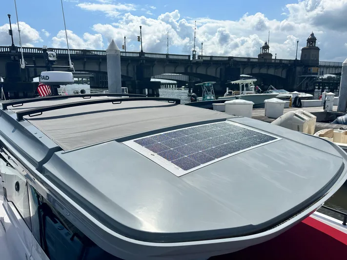 Rachel's Glory Yacht Photos Pics 2022 Axopar 37 XC Cross Cabin BRABUS LINE docked near a bridge under a partly cloudy sky.