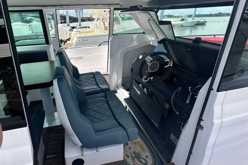 Rachel's Glory Yacht Photos Pics Interior of 2022 Axopar 37 XC CROSS CABIN with seating and steering console.