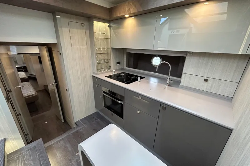 Yacht Photos Pics Modern kitchen interior of 2023 Cranchi 60 ST yacht, featuring sleek cabinetry and appliances.