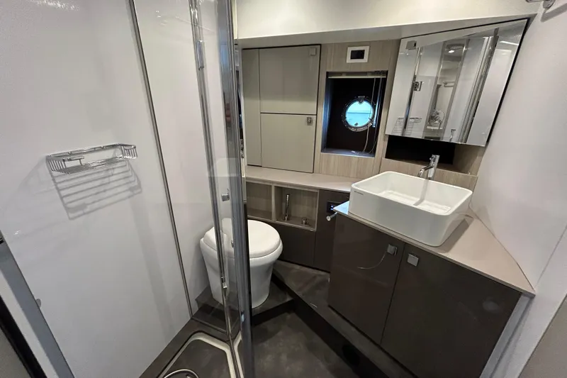  Yacht Photos Pics Modern bathroom interior on 2023 Cranchi 60 ST yacht, featuring sleek fixtures and a porthole window.