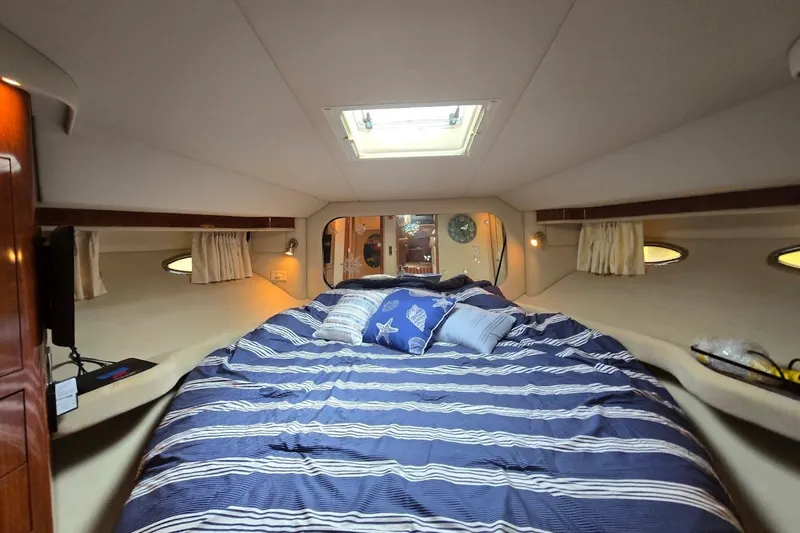 Mojito Yacht Photos Pics Luxurious 2004 Sea Ray 480 Motor Yacht bedroom with striped bedding and cozy lighting.