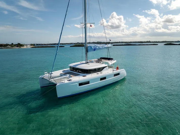 Watercolor Yacht Photos Pics 2023 Lagoon 46 catamaran sailing on clear turquoise waters under a sunny sky.