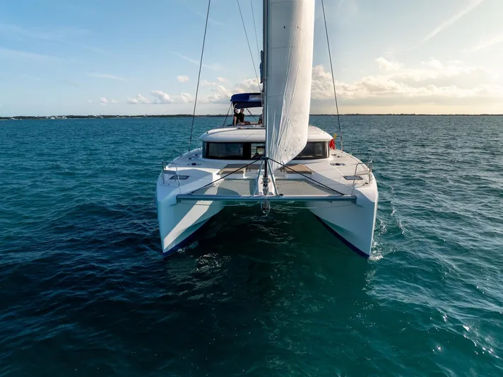 Watercolor Yacht Photos Pics 2023 Lagoon 46 catamaran sailing on open sea under clear sky.