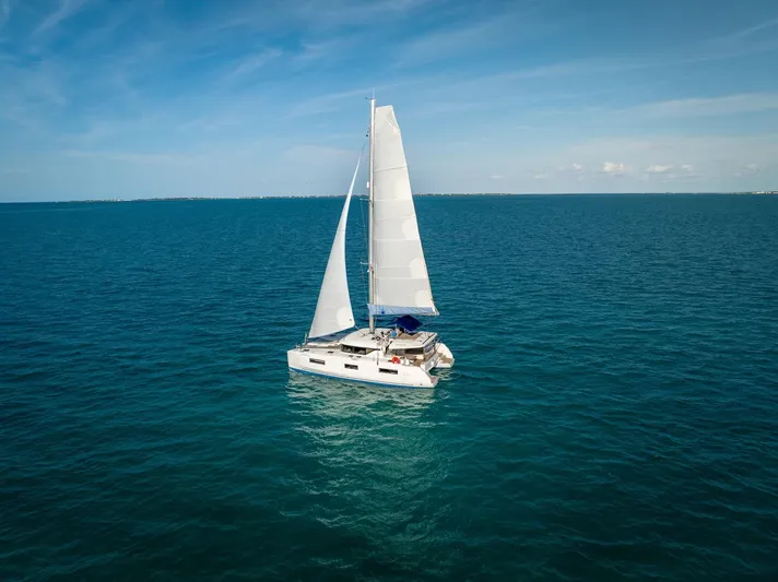 Watercolor Yacht Photos Pics 2023 Lagoon 46 catamaran sailing on open blue sea under clear skies.