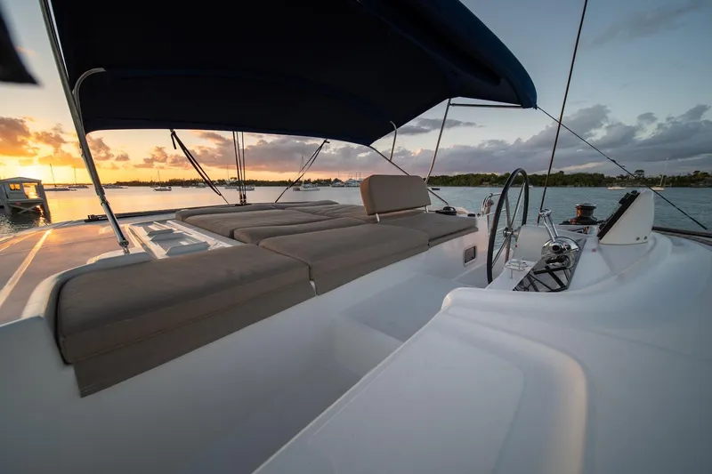 Watercolor Yacht Photos Pics 2023 Lagoon 46 catamaran deck at sunset, featuring comfortable seating and elegant design.