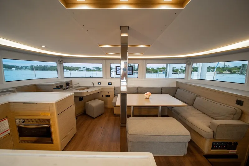 Watercolor Yacht Photos Pics Luxurious interior of 2023 Lagoon 46 catamaran with modern furnishings and panoramic windows.
