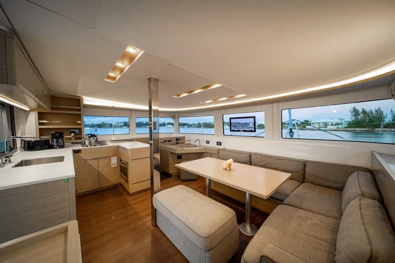 Watercolor Yacht Photos Pics Luxurious interior of 2023 Lagoon 46 catamaran with modern kitchen and spacious seating area.