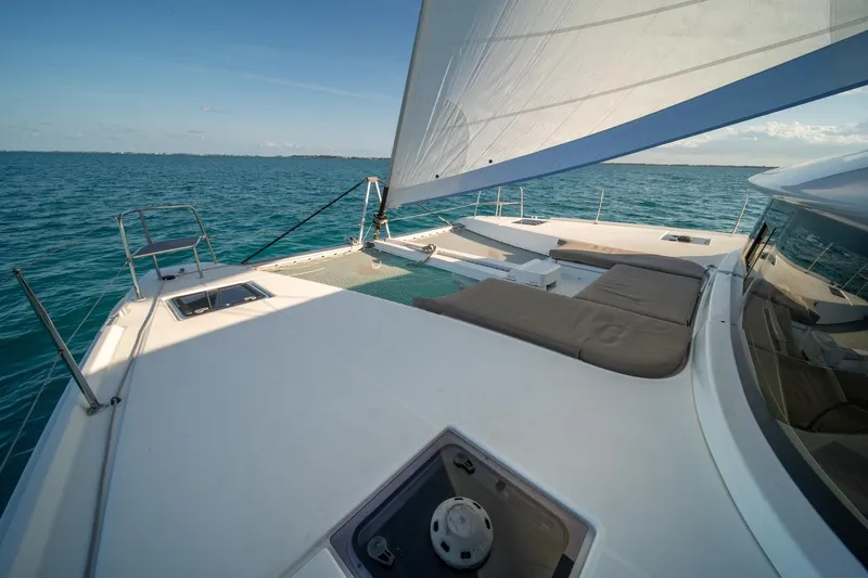 Watercolor Yacht Photos Pics 2023 Lagoon 46 catamaran sailing on open sea with spacious deck and sunbathing area.