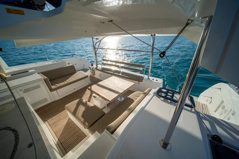 Watercolor Yacht Photos Pics Luxurious 2023 Lagoon 46 catamaran deck with seating, overlooking serene ocean waters.
