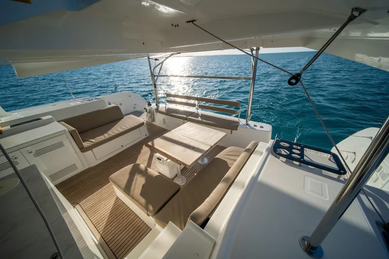 Watercolor Yacht Photos Pics Luxurious 2023 Lagoon 46 catamaran deck with seating, overlooking serene ocean waters.