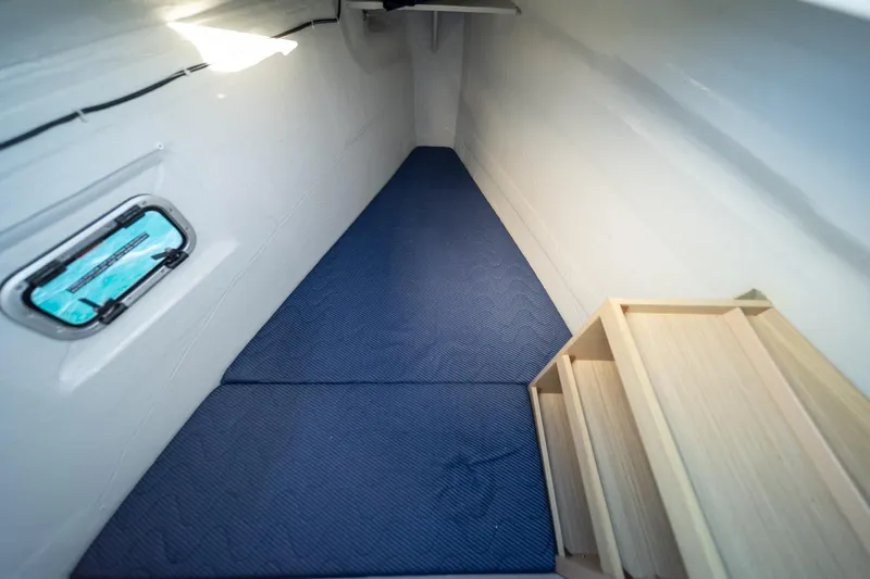 Watercolor Yacht Photos Pics Interior cabin of 2023 Lagoon 46 yacht with blue mattress and wooden steps.