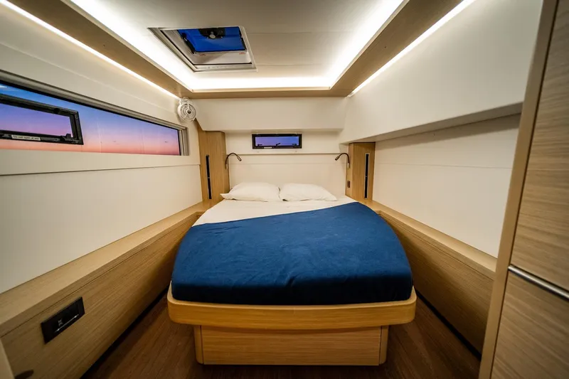Watercolor Yacht Photos Pics Luxurious cabin interior of 2023 Lagoon 46 yacht with cozy bed and modern lighting.